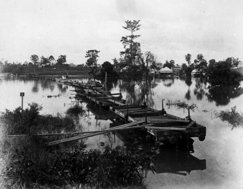 Makeshift bridge of railway wagons during the 1890 flood in Auchenflower. (State Library of Queensland, Negative no. 22684)