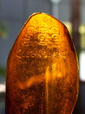 A piece of glass embossed with the Brisbane Bottle Exchange logo.